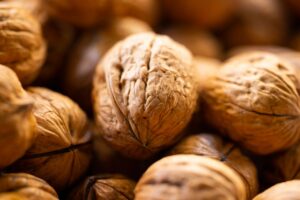 Detailed close-up image of walnuts in shell, showing texture and natural color.