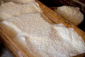 Detailed shot of powdered grain stacked in a rustic wooden box.