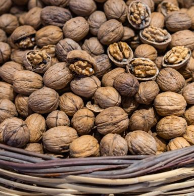 A rustic basket brimming with organic walnuts, showcasing natural and raw food photography.